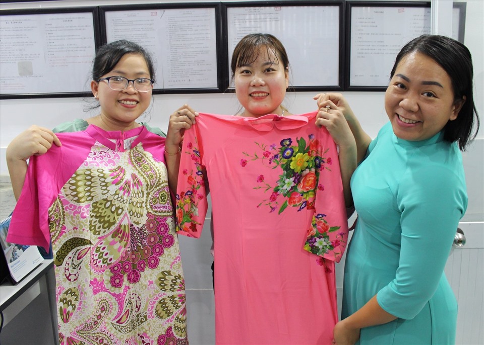 Các nữ công nhân lao động ướm thử áo dài. Ảnh Đức Long
