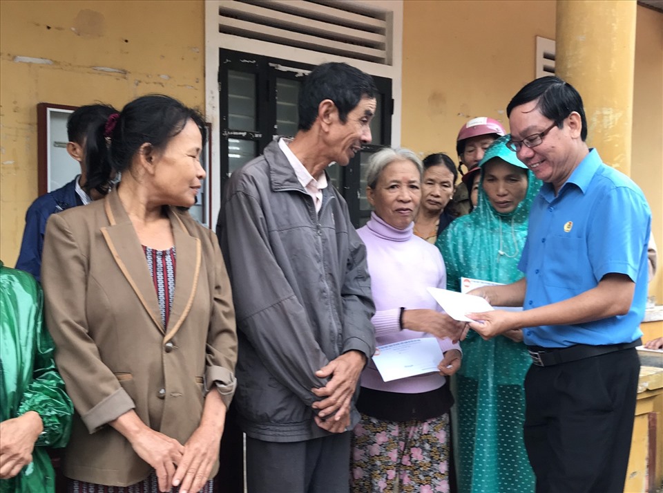 Chủ tịch LĐLĐ tỉnh Quảng Trị Nguyễn Thế Lập trao quà hỗ trợ cho người dân vùng lũ tại xã Gio Mỹ, huyện Gio Linh. Ảnh: Tài Minh.