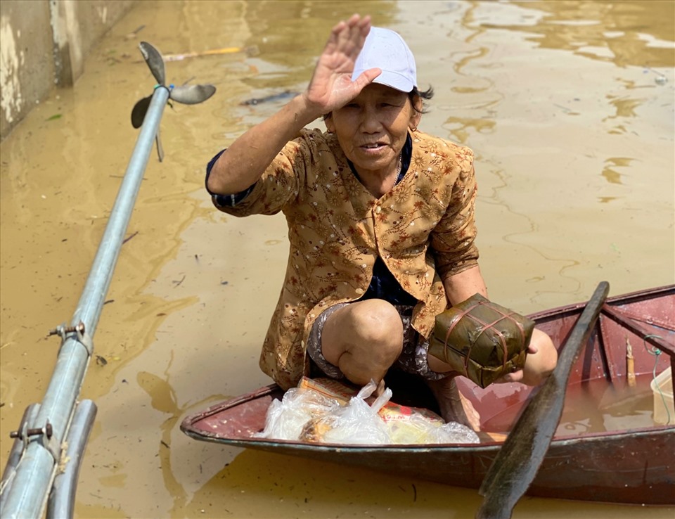 Người dân vũng lũ Lệ Thủy nhận hàng cứu trợ trong nước lũ chiều 22.10. Ảnh: Lê Phi Long