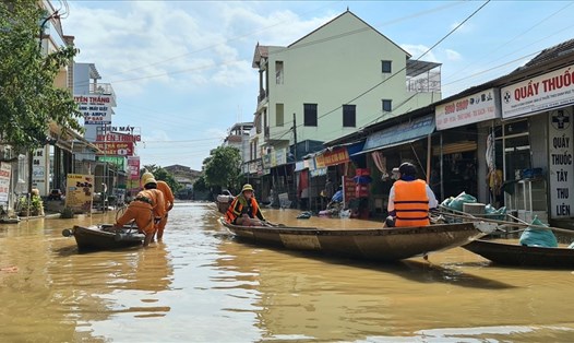 Đường phố vẫn đang biến thành sông. Ảnh: Thuyền vận chuyển hàng cứu trợ chiều 22.10 tại xã Võ Ninh, huyện Quảng Ninh. Ảnh: Lê Phi Long