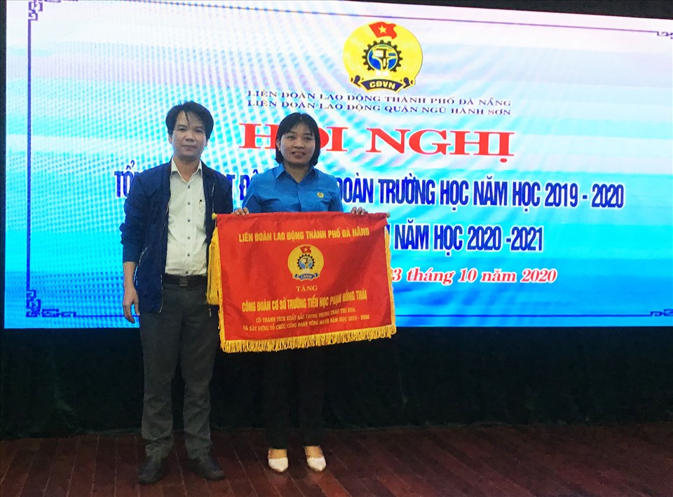 Ông Lê Trọng Nguyên (bên trái) - Trường Ban Tuyên giáo LĐLĐ TP Đà Nẵng tặng cờ thi đua cho CĐCS khối trường học có thành tích xuất sắc trong học động CĐ năm học 2019-2020. Ảnh Thái Bình