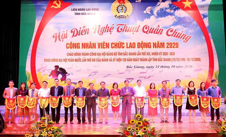 Lãnh đạo LĐLĐ tỉnh Bắc Giang trao Cờ lưu niệm cho các đơn vị tham gia. Ảnh: Cổng thông tin điện tử tỉnh Bắc Giang.