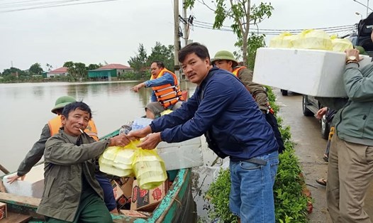 Thầy Nguyễn Quốc Hiệp (áo xanh) trao quà cho người dân bị lũ lụt Hà Tĩnh. Ảnh: Quốc Hải