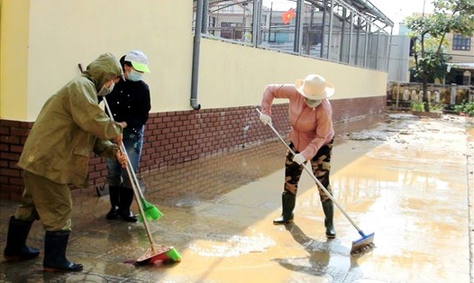 Người dân Quảng Bình dọn dẹp bùn đất sau mưa lũ. Ảnh: LPL