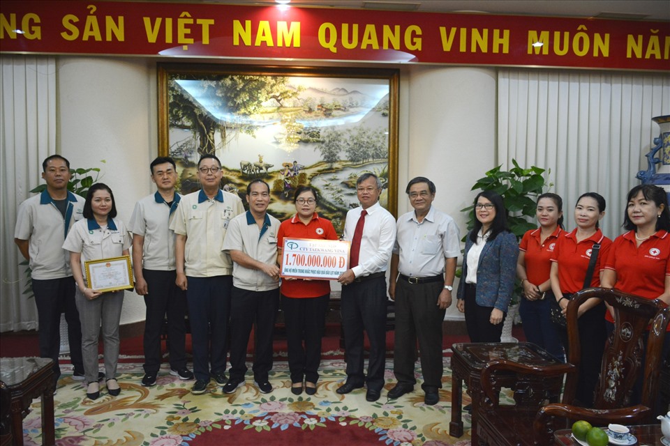 Chủ tịch UBND tỉnh Đồng Nai - Cao Tiến Dũng, Hội chữ thập đỏ tỉnh Đồng Nai tiếp nhận bảng tượng trưng tiền, hiện vật trị giá 1,7 tỉ đồng do Ban giám đốc và đoàn viên lao động Công ty cổ phần Taekwang Vina ủng hộ, cứu trợ đồng bào các tỉnh miền Trung bị bão lũ. Ảnh: Minh Châu