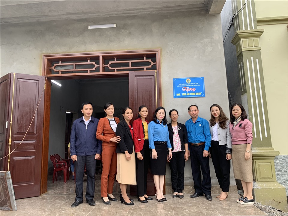 Ông Vũ Tất Thành - Phó Chủ tịch LĐLĐ tỉnh chụp ảnh lưu niệm cùng gia đình chị Bốn, cán bộ công đoàn chuyên trách, BCH Công đoàn trường mầm non Liêm Phong cùng lãnh đạo thôn, xóm. Ảnh: Phúc Lộc
