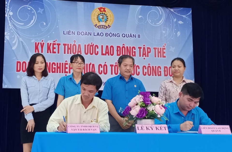 Ông Nguyễn Trọng Nghĩa (ngồi bên phải), ký thỏa ước lao động tập thể với đại diện Công ty Bách Vạn. Ảnh Đức Long