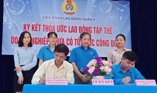 Ông Nguyễn Trọng Nghĩa (ngồi bên phải), ký thỏa ước lao động tập thể với đại diện Công ty Bách Vạn. Ảnh Đức Long