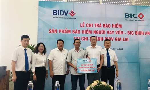 Đại diện lãnh đạo BIC và Chi nhánh BIDV trao tiền bảo hiểm cho gia đình khách hàng. Ảnh: BIC