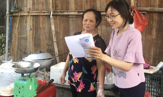 Bà Trần Thị Minh Thịnh (bên phải) tuyên truyền chính sách BHXH đến người lao động tự do. Ảnh: Minh Đức