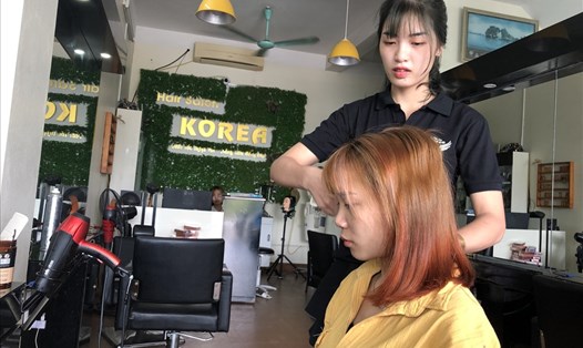 Chị Vũ Thị Duyên đang chăm sóc tóc cho khách. Ảnh: Bảo Hân