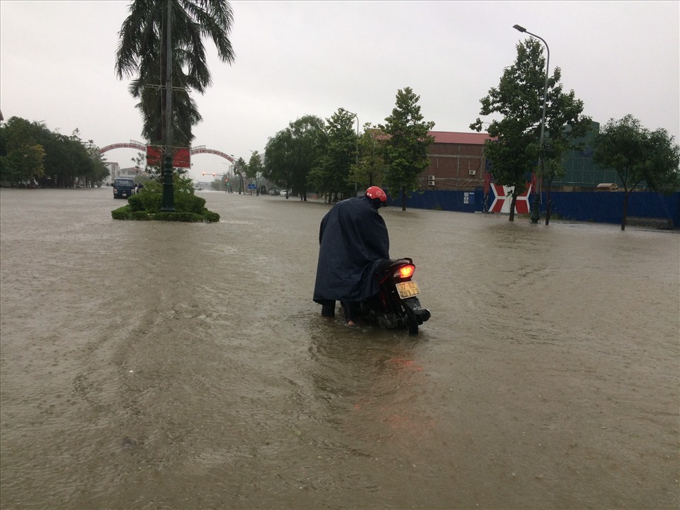 Đường phố ngập sâu, người dân TP. Vinh dắt xe 'bơi" trong biển nước. Ảnh: Trần Tuyên