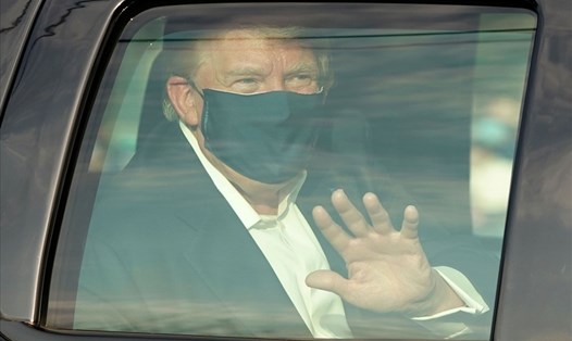 Tổng thống Donald Trump ngồi trong xe vẫy tay chào người ủng hộ bên ngoài Trung tâm Quân y quốc gia Walter Reed hôm 4.10. Ảnh: AFP
