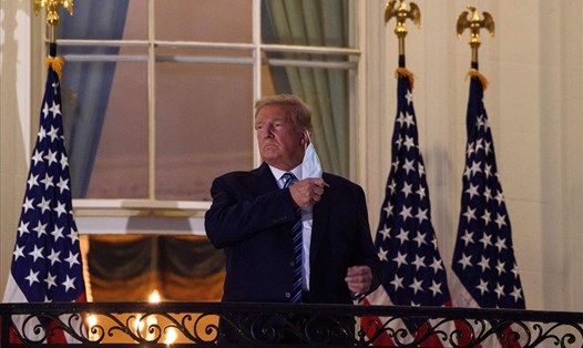 Tổng thống Donald Trump tháo khẩu trang sau khi xuất viện trở về Nhà Trắng hôm 5.10. Ảnh: AFP