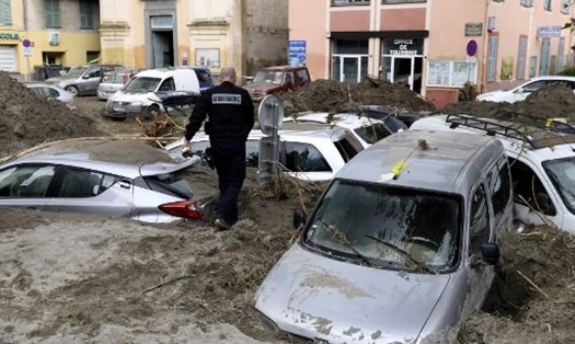 Người dân Italia dọn dẹp đường phố đầy bùn đất do bão lũ tấn công. Ảnh: AFP
