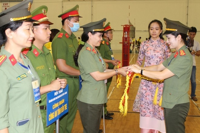 Trung tá Công Thanh Thảo - Chủ tịch Công đoàn Công an Nhân dân (bên phải ảnh) tặng cờ lưu niệm cho các đội tham gia Hội thao. Ảnh: CĐCAND