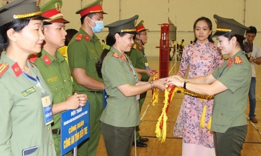 Trung tá Công Thanh Thảo - Chủ tịch Công đoàn Công an Nhân dân (bên phải ảnh) tặng cờ lưu niệm cho các đội tham gia Hội thao. Ảnh: CĐCAND