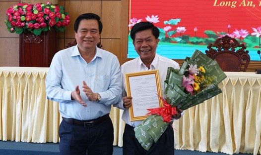 Chủ tịch HĐND tỉnh Long An - ông Phạm Văn Rạnh - trao quyết định nghỉ hưu cho ông Trần Văn Cần (phải). Ảnh: L.A