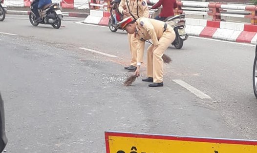 Lực lượng Cảnh sát giao thông dọn dẹp một đoạn đá vương vãi trên đường. Ảnh: D.H.