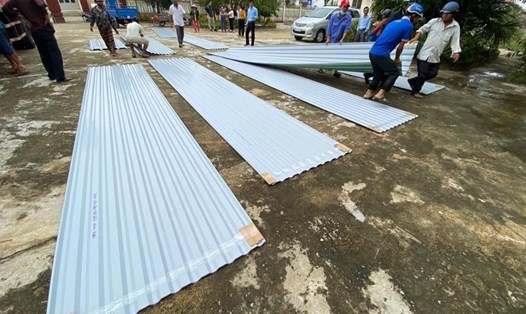 Đoàn cứu trợ cấp tôn cho người dân vùng lũ lụt Miền Trung lợp lại nhà tại Tư Nghĩa, tỉnh Quảng Ngãi. Ảnh NTH
