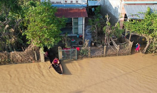 Người dân "rốn lũ" xã An Định, huyện Tuy An, Phú Yên vất vả đi lại sau bão số 12. Ảnh: Nhiệt Băng