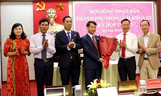 Ông Hồ Quang Huy (giữa) - tân Chủ tịch UBND TP.Móng Cái - nhận hoa chúc mừng. Ảnh: Thu Hằng