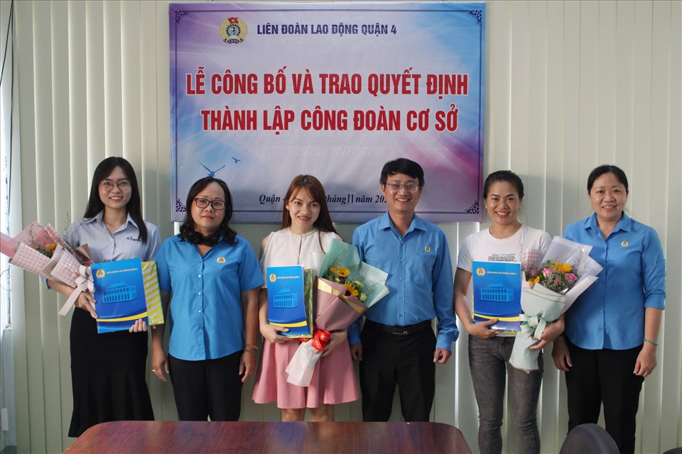 Đại diện LĐLĐ quận 4, TPHCM tặng hoa cho đại diện Ban chấp hành công đoàn cơ sở. Ảnh Đức Long