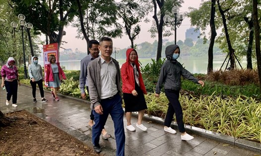 Một số người dân đi bộ ở khu vực hồ Hoàn Kiếm không đeo khẩu trang ngày 16.11. Ảnh: Phạm Đông