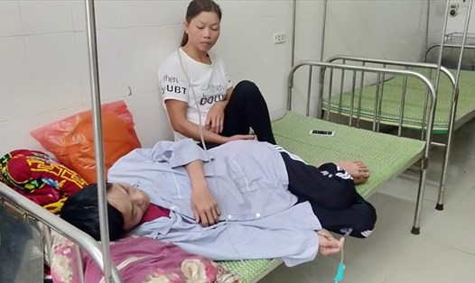Chị Nguyễn Thị Hương đang chăm sóc chồng tại bệnh viện. 
Ảnh: Bảo Hân