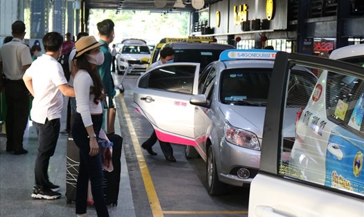 Hành khách đón taxi ở làn D ở sân bay Tân Sơn Nhất.  Ảnh: Minh Quân