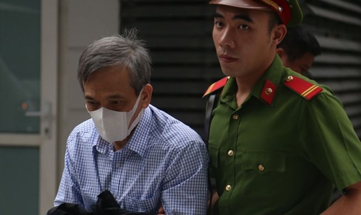 Cựu Phó Tổng Giám đốc BIDV - Trần Lục Lang (trái) bị dẫn giải vào phòng xét xử. Ảnh: V.Dũng.