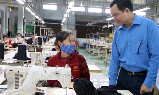 Chủ tịch Tổng LĐLĐVN Nguyễn Đình Khang hỏi thăm đời sống của người lao động ở một doanh nghiệp may mặc tại tỉnh Quảng Trị. Ảnh: Hưng Thơ