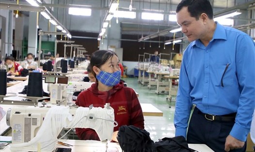 Chủ tịch Tổng LĐLĐVN Nguyễn Đình Khang hỏi thăm đời sống của người lao động ở một doanh nghiệp may mặc tại tỉnh Quảng Trị. Ảnh: Hưng Thơ