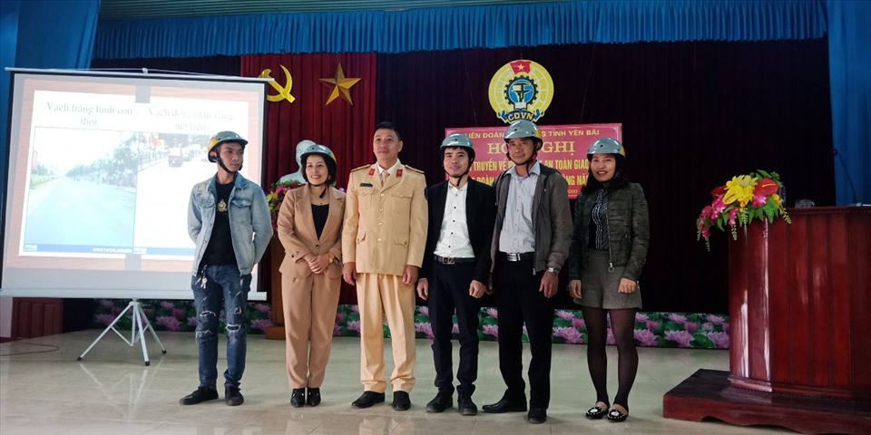 Cán bộ Đội Giao thông công an Huyện Trấn Yên tặng mũ bảo hiểm cho đoàn viên. Ảnh: Xuân Hiền