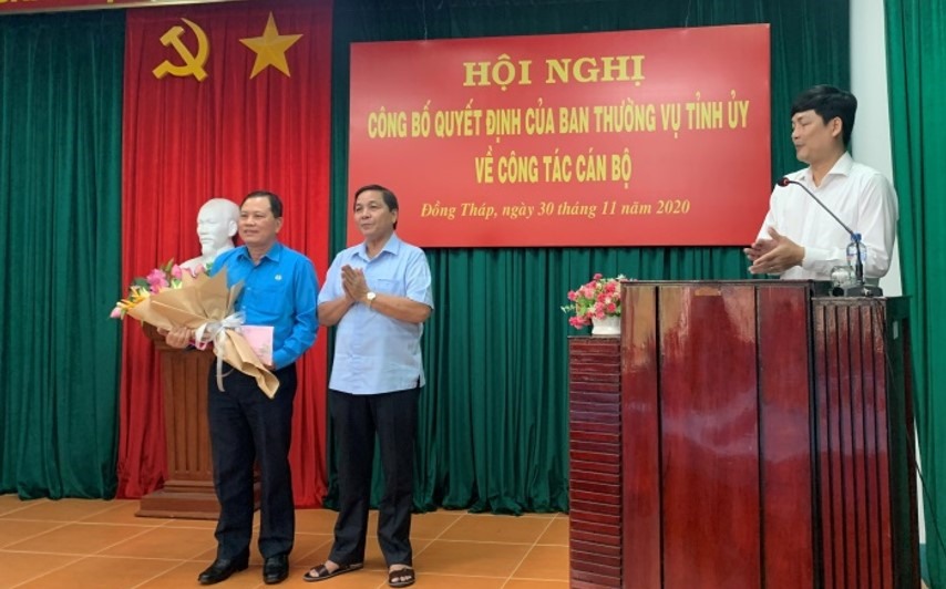 Đồng chí Lê Thành Công, Trưởng Ban Dân vận, Chủ tịch Mặt trận Tổ quốc Việt Nam tỉnh Đồng Tháp trao quyết định nghỉ hưu và tặng hoa cho đồng chí Nguyễn Thanh  Nhàn. Ảnh: Lưu Hùng