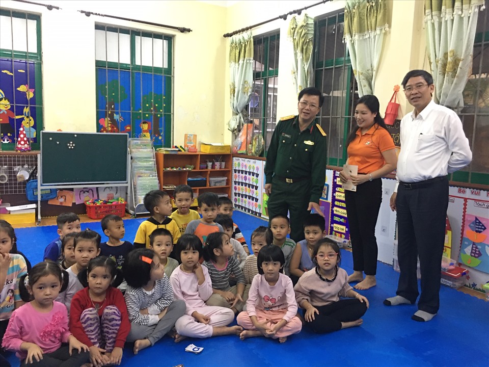 Chủ tịch Công đoàn Giáo dục Việt Nam (áo trắng) Vũ Minh Đức và đại tá Nguyễn Đình Đức thăm các cháu Trường mầm non Hoa phượng. Ảnh: Hải Anh
