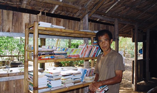 Ông Nguyễn Đăng Được bên thư viện sách cho trẻ em xóm phao. Ảnh: Kim Anh