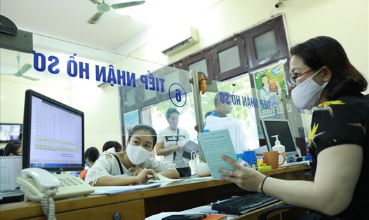 Nhân viên BHXH quận Cầu Giấy (TP.Hà Nội) hướng dẫn người dân hoàn thiện thủ tục. Ảnh: Hải Nguyễn