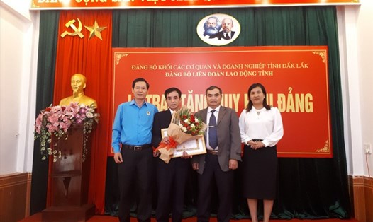 Đảng bộ Khối các Cơ quan và Doanh nghiệp, Đảng bộ LĐLĐ tỉnh Đắk Lắk trao tặng hoa và huy hiệu 40 năm tuổi Đảng cho ông Nguyễn Lương Tân. Ảnh: T.X