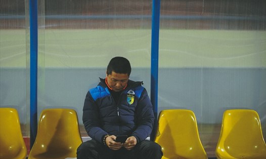 Huấn luyện viên Chu Đình Nghiêm ngồi lặng lẽ sau khi Hà Nội mất chức vô địch V.League 2017 trên sân Cẩm Phả. Ảnh: Đăng Huỳnh