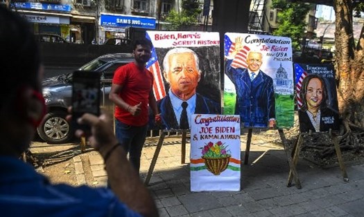 Người dân vui vẻ chụp ảnh kỉ niệm bên những tranh đánh dấu thắng lợi của Tổng thống đắc cử Joe Biden và Phó Tổng thống đắc cử Kamala Harris - một người phụ nữ Mỹ gốc Ấn. Ảnh: AFP
