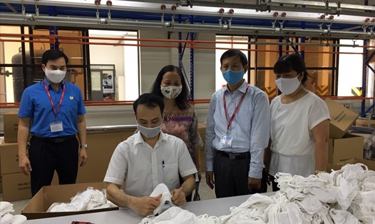 Cán bộ Tổng Liên đoàn Lao động Việt Nam, Công đoàn Dệt may Việt Nam thăm những giáo viên Trường Cao đẳng nghề Long Biên bị ảnh hưởng do COVID-19 phải tạm nghỉ dạy được bố trí làm tại dây chuyền sản xuất khẩu trang hồi tháng 3.2020. Ảnh: Hải Anh