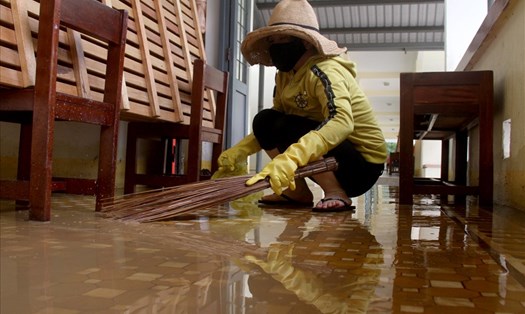 Một giáo viên trên địa bàn TP.Quy Nhơn (tỉnh Bình Định) lau chùi trường lớp trong đợt bão, lũ vừa qua. Ảnh: N.T