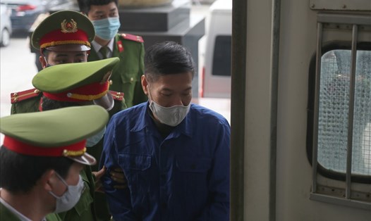 Cựu Giám đốc CDC Hà Nội Nguyễn Nhật Cảm bị dẫn giải vào phòng xét xử. Ảnh: V.Dũng.