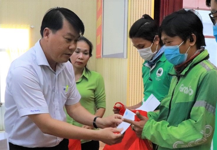 Ông Nguyễn Văn Hải (bên trái), Chủ tịch LĐLĐ Quận Bình Tân, trao quà cho các đoàn viên Nghiệp đoàn xe công nghệ. Ảnh Đức Long