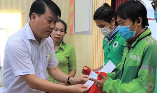 Ông Nguyễn Văn Hải (bên trái), Chủ tịch LĐLĐ Quận Bình Tân, trao quà cho các đoàn viên Nghiệp đoàn xe công nghệ. Ảnh Đức Long