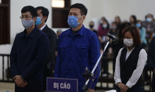 Các bị cáo, trong đó có cựu Giám đốc CDC Hà Nội Nguyễn Nhật Cảm (áo xanh đậm, hàng đầu) nghe toà tuyên án. Ảnh: V.Dũng.