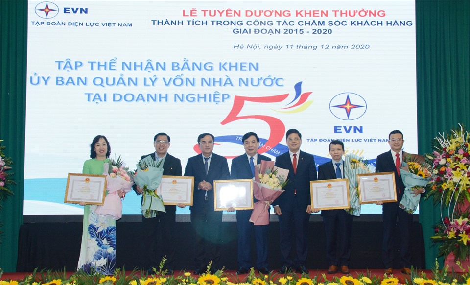 Ông Nguyễn Phú Hoài Nghĩa - Giám đốc Trung tâm chăm sóc khách hàng Điện lực miền Nam (bên phải) - nhận bằng khen của Ủy ban Quản lý vốn nhà nước tại doanh nghiệp. Ảnh EVNSPC cung cấp.