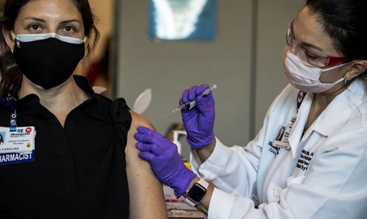 Diana Carolina, một bác sĩ ở Mỹ, được đồng nghiệp tiêm vaccine COVID-19 của Pfizer-BioNtech tại Miramar, Florida, hôm 14.12. Ảnh: AFP.