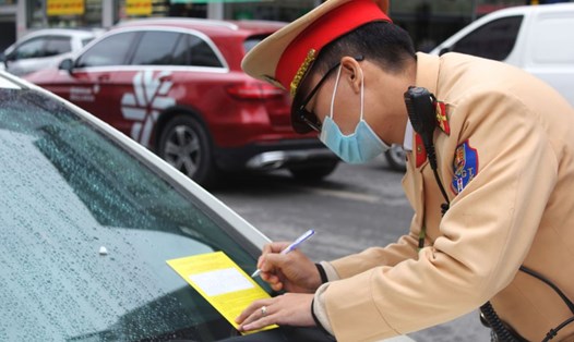Dán thông báo phạt nguội các phương tiện dừng đỗ sai quy định tại một tuyến phố ở Hà Nội (ảnh chụp sáng ngày 15.12). Ảnh: PHẠM ĐÔNG